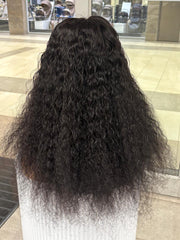 Rear view of a long black curly wig on a mannequin