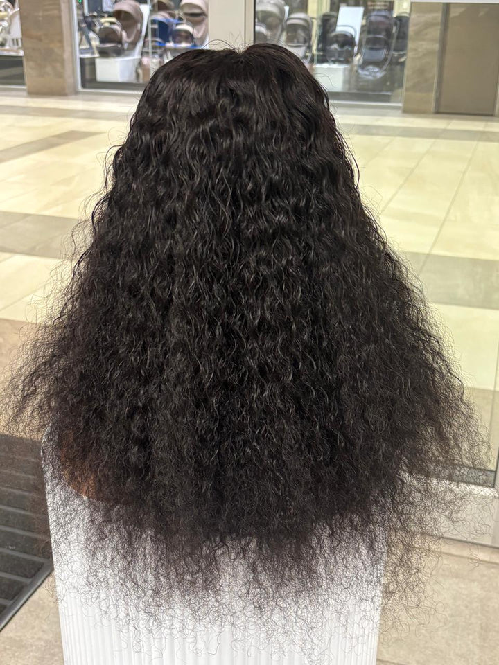 Rear view of a long black curly wig on a mannequin