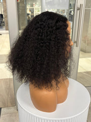 Side view of a full black curly wig on a mannequin