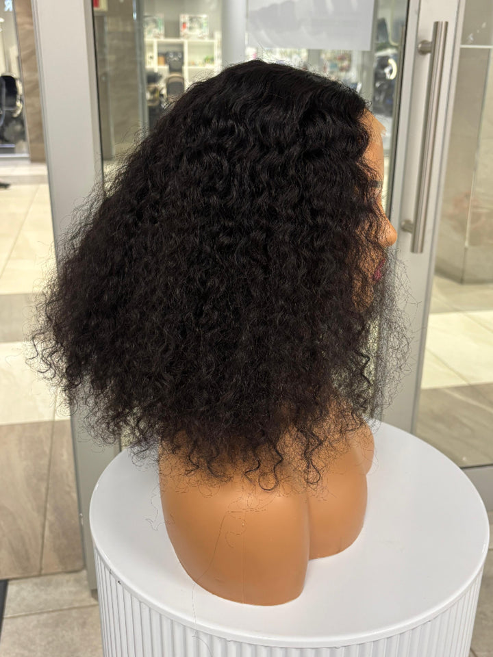 Side view of a full black curly wig on a mannequin