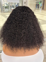 Rear view of a full black curly wig on a mannequin