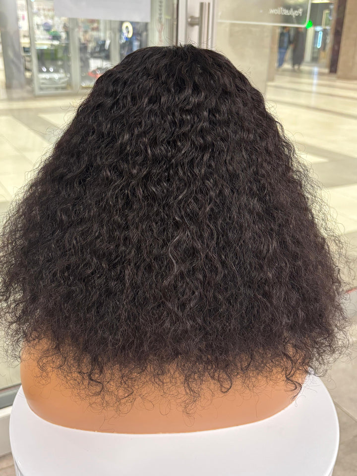 Rear view of a full black curly wig on a mannequin