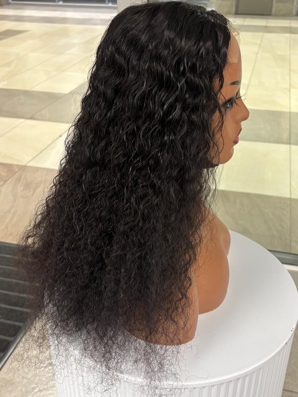 Side view of a long black curly wig on a mannequin