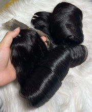Close-up of black hair bundles styled in large rolled curls