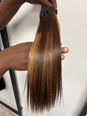 Brown straight hair bundle with warm highlights held vertically