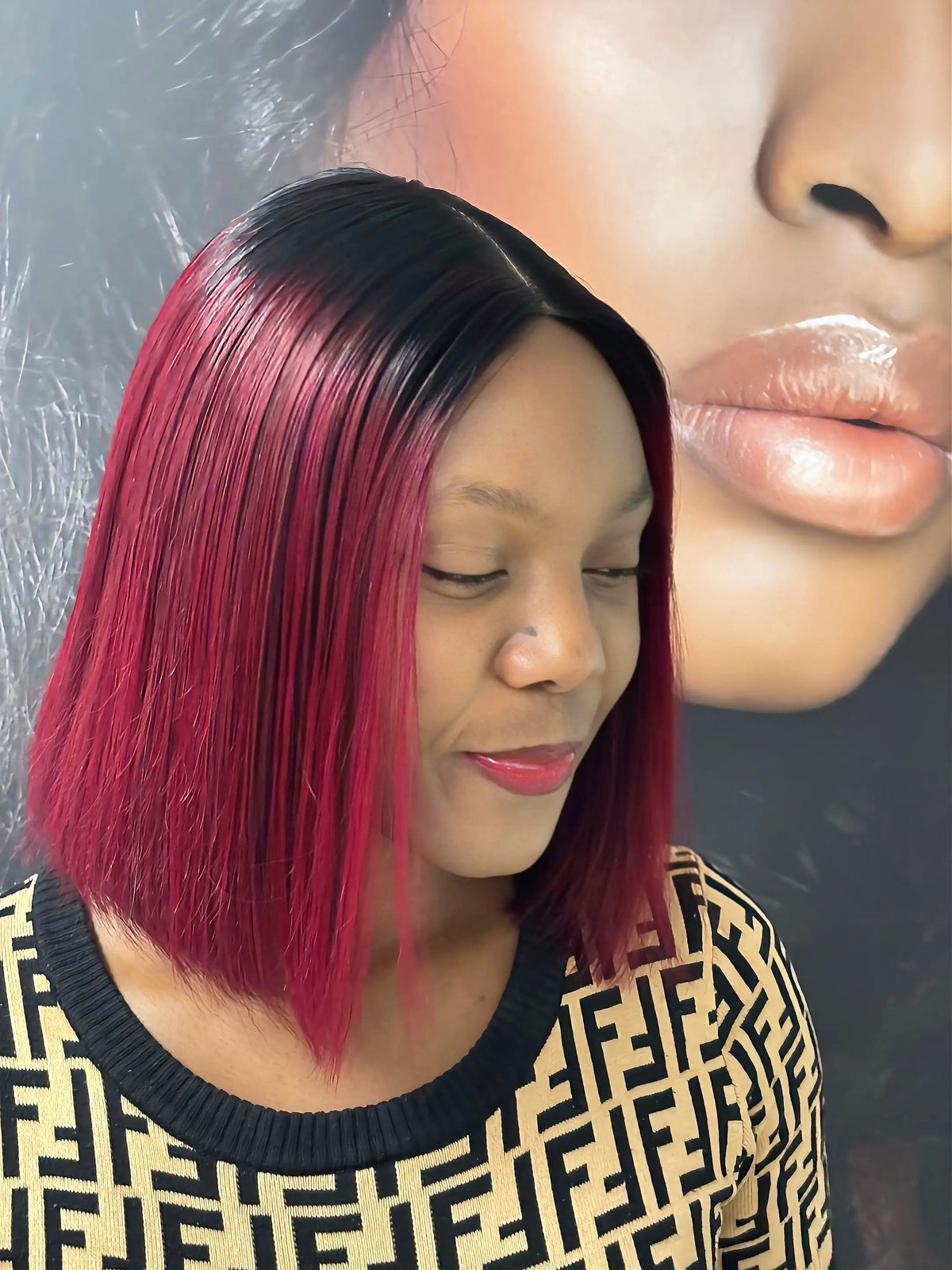 Close-up of a burgundy bob wig with black roots on a model