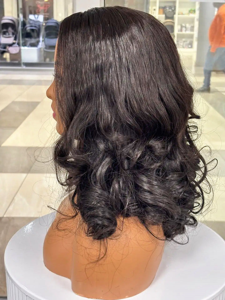 Side view of a black wig with smooth roots and large curls on a mannequin
