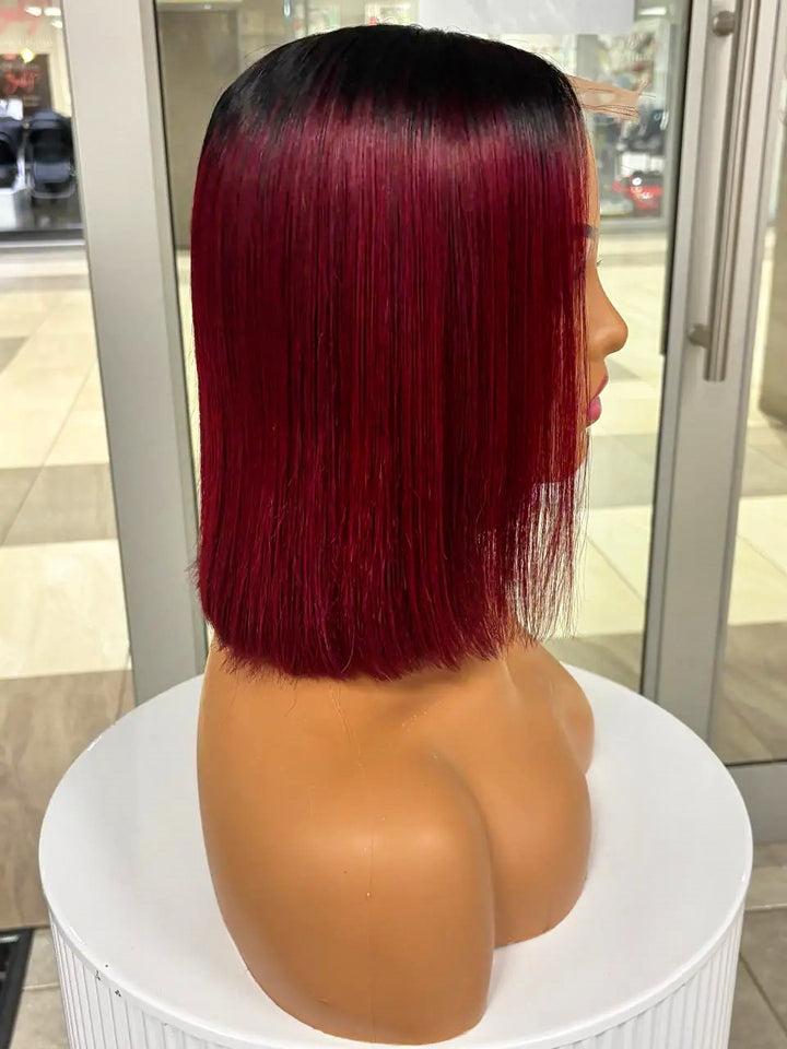 Side view of a burgundy bob wig with black roots on a mannequin