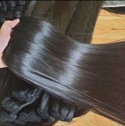Black straight hair bundle spread across a hand to show its smooth texture